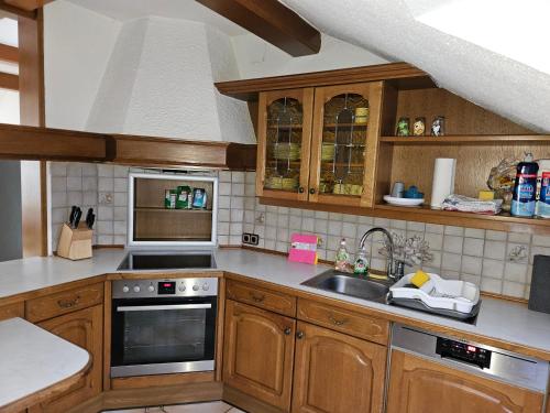 a kitchen with wooden cabinets and a sink at Appartement "Toni" 
