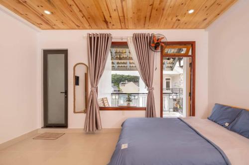 a bedroom with a bed and a large window at LaMay Homestay in Da Lat