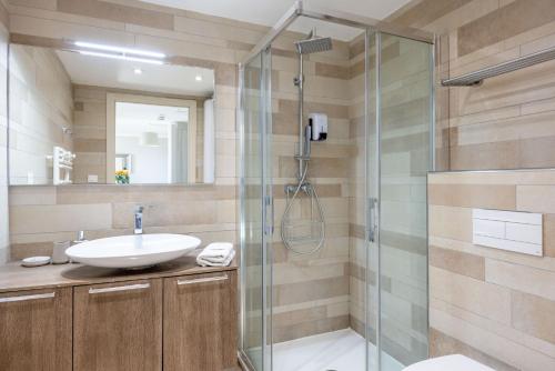 La salle de bains est pourvue d'un lavabo et d'une douche. dans l'établissement LE MIDI 8 by ESTATES CANNES, à Cannes