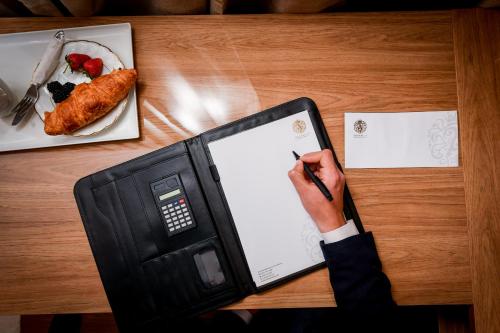 a person holding a pen and a tablet on a table at Arabella Premium Residence - New Cairo in Cairo