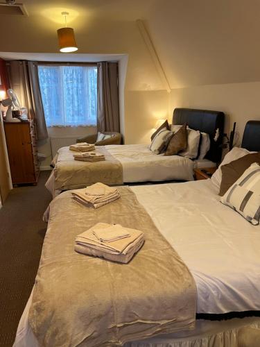 a hotel room with two beds with towels on them at The Singlecote Hotel in Lincolnshire