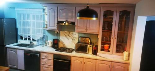 a kitchen with white cabinets and a microwave at Villa Tourelle of Paradise with bigPrivate Pool in Rivière Noire