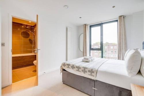 a white bedroom with a large bed and a shower at Cozy in Camden Town/Balcony in London