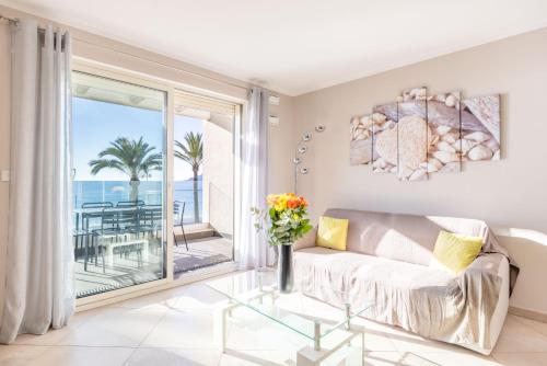 - un salon avec un canapé et une vue sur l'océan dans l'établissement LE MIDI 8 by ESTATES CANNES, à Cannes