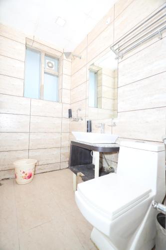 a bathroom with a white toilet and a sink at Hotel Wedlock 51 in Gurgaon