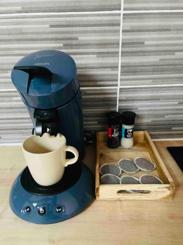 a blue coffee maker with a cup of coffee at Le Grand Studio in Castres
