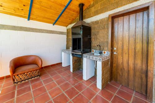 a kitchen with a brick wall and a wooden door at PANWEWE III in San Antonio de las Alzanas