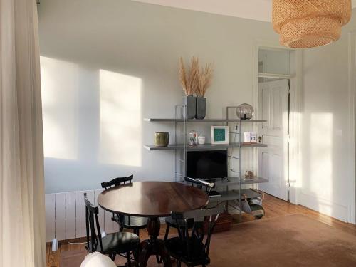 a dining room with a table and a television at Lisbon Evergreen Apartment in Lisbon