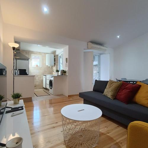 a living room with a couch and a table at Tomarhousing - Style in Tomar