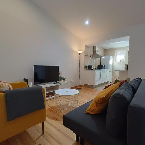 a living room with a couch and a tv at Tomarhousing - Style in Tomar