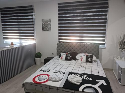 1 dormitorio con cama con edredón en Apartman u centru, en Šid