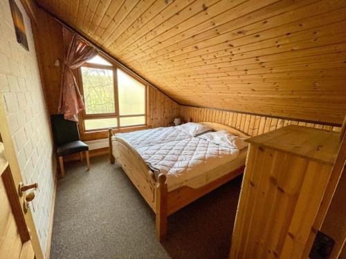 - une chambre avec un lit dans une pièce en bois dans l'établissement Ferienhaus Sinja, à Bremke