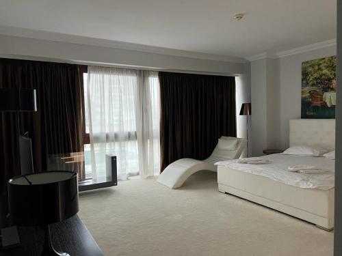 a white bedroom with a bed and a window at SilverDeluxe in Poiana Brasov