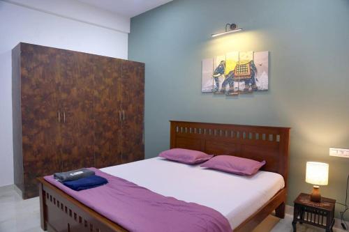 een slaapkamer met een groot bed met paarse kussens bij Veetil -3BHK A/C, Kukatpally, Hyderabad in Hyderabad