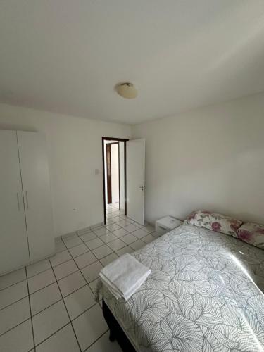 a bedroom with a bed and a tiled floor at Apês Completos na Litorânea l Cozinha e Conforto l Ferreira Hospedagens in São Luís