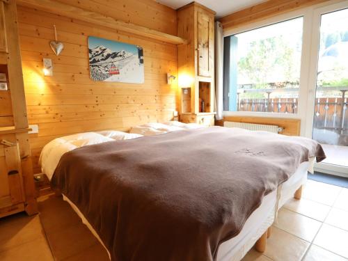 a bedroom with two beds in a wooden wall at Appartement de charme au pied des pistes, centre des Gets, balcon et terrasse, 2 chambres, Wi-Fi gratuit - FR-1-623-268 in Les Gets