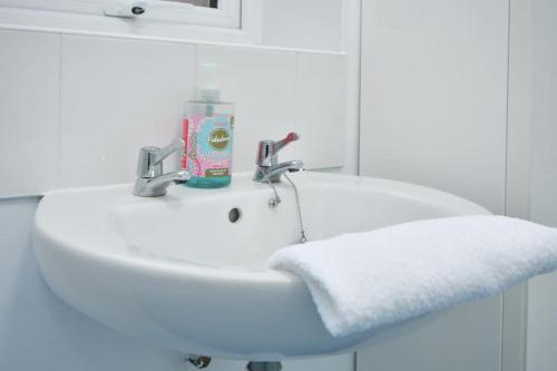 a white bathroom sink with a towel on it at Ernest House - By Sigma Stays in Crewe