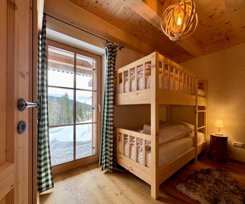 1 dormitorio con litera y ventana en Edelweiss Chalet, en Oberwölz Stadt