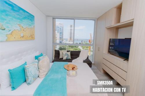 sala de estar con cama y TV en Apartamentos Salguero Suites - Cerca al Mar by SOHO en Santa Marta