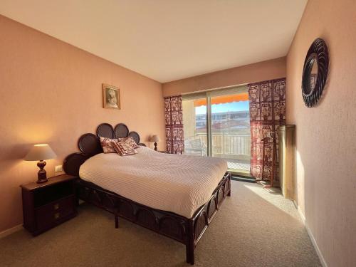 une chambre avec un lit et une grande fenêtre dans l'établissement Vintage Apartment by Welcome to Cannes, à Cannes