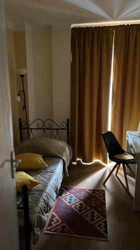une chambre avec un lit, une chaise et une fenêtre dans l'établissement Chambre privative (pré de la Gare Matabiau SNCF) 2, à Toulouse