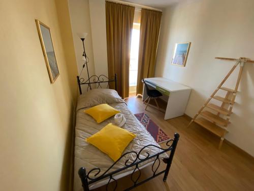 Cette chambre comprend un lit avec des oreillers jaunes et un bureau. dans l'établissement Chambre privative (pré de la Gare Matabiau SNCF) 2, à Toulouse