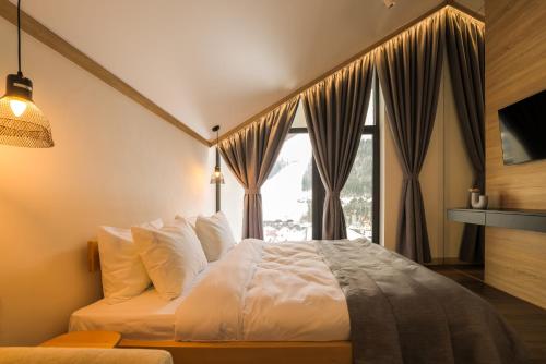 a bedroom with a bed and a window at Black & White Villas by Fomich Hotels Group in Bukovel
