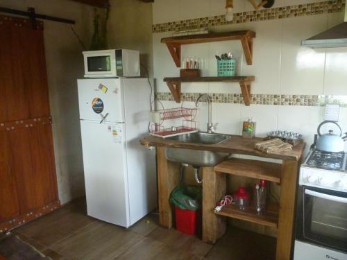a kitchen with a white refrigerator and a sink at IDALIA in Barra del Chuy