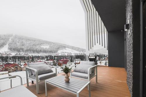 a living room with two chairs and a table at Black & White Villas by Fomich Hotels Group in Bukovel