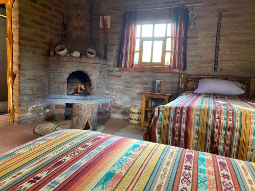 1 dormitorio con 1 cama y chimenea de piedra en Kallpa Wasi, en Cotacachi