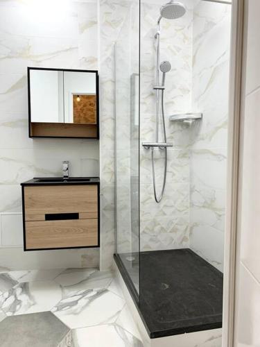 une salle de bain blanche avec une douche et un lavabo dans l'établissement Appartement Secteur Gare et Place de la Comédie, Wifi et Climatisation, à Montpellier