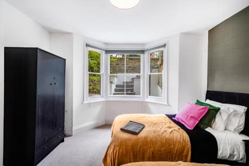 a bedroom with a bed and a large window at Classy Abode in Hackney - Garden - Sleeps 6 in London