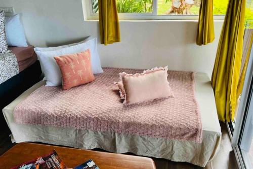una cama pequeña con almohadas en una habitación en MOOREA Bungalow Kohimana avec vue lagon, en Moorea