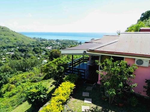 a house on a hill with a view of the ocean at MOOREA Bungalow Kohimana avec vue lagon in Moorea