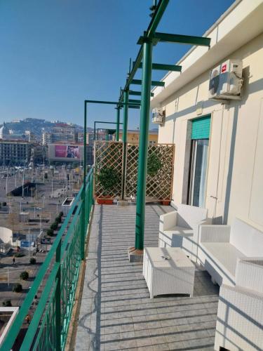 balcón con sillas blancas y vistas a la ciudad en Attico Central Station Napoli, en Nápoles