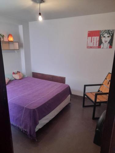 1 dormitorio con 1 cama de color púrpura y 1 silla en Casabunda Multiespacio - Habitación privada en Salta