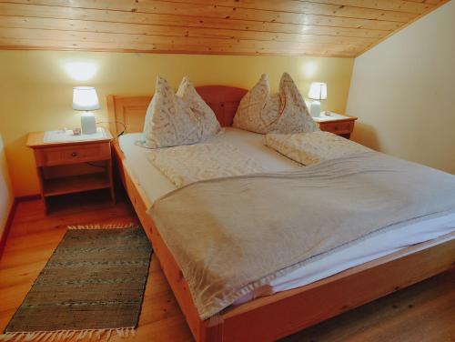 a bed in a room with two night stands and two lamps at Ferienwohnung Grubinger in Unterach am Attersee