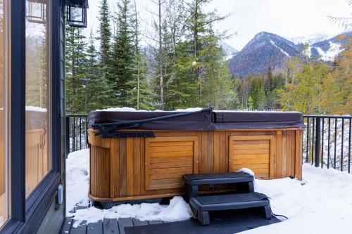 a hot tub on a porch in the snow at Powder House Chalet by Fernie Central Reservations in Fernie