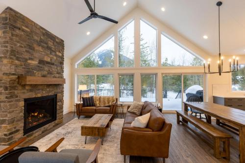 a living room with a fireplace and a stone wall at Powder House Chalet by Fernie Central Reservations in Fernie