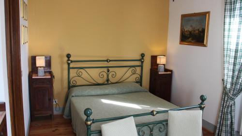 1 dormitorio con 1 cama verde y 2 sillas en Agriturismo Borgo Santa Lucia, en Castiglion Fiorentino