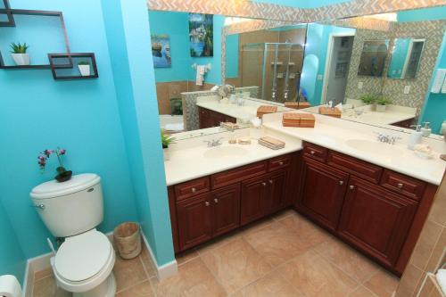 ein Badezimmer mit zwei Waschbecken, einem WC und einem Spiegel in der Unterkunft Come stroll along the beach and enjoy shared resort style amenities! in Palm Coast