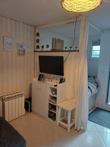 Cette chambre dispose d'une télévision et d'une chaise. dans l'établissement La Cabane de Dadou Lacanau, à Lacanau