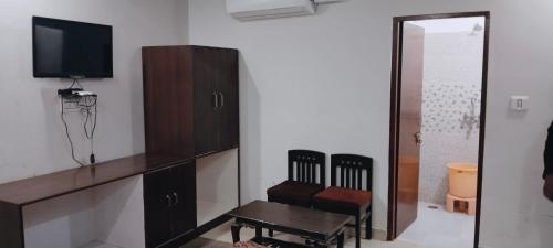 a living room with a tv and a table and chairs at Tiger Guest House & Restaurant in Sawāi Mādhopur
