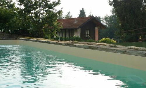 uma casa ao lado de uma piscina de água com uma casa em Navilla em Torresina