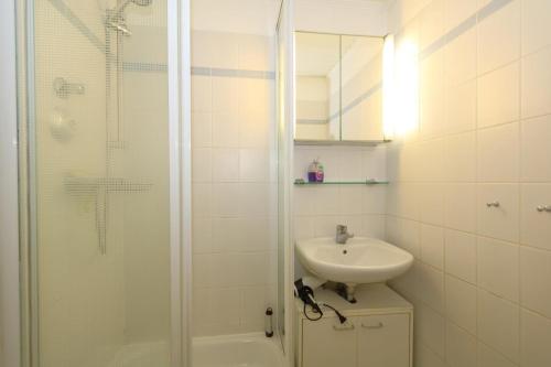 y baño blanco con lavabo y ducha. en Atlantik-1-41-an-der-„Sylter-Welle“, en Westerland