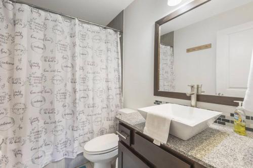 uma casa de banho com um lavatório, um WC e uma cortina de chuveiro. em Cozy 2 Bed Townhome near the Hospital em Lafayette