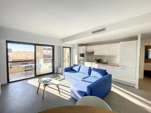un salon avec un canapé bleu et une cuisine dans l'établissement Stunning 1 BR 3 pers Résidence Cannes Suquet Vieux Port Croisette 1 mn by Olam Properties, à Cannes