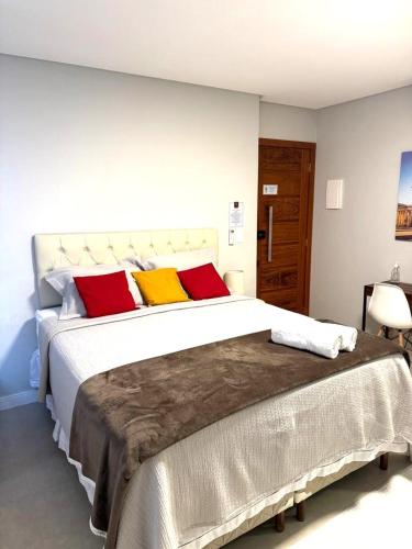 a bedroom with a large bed with red and yellow pillows at Canto Alemão in Domingos Martins