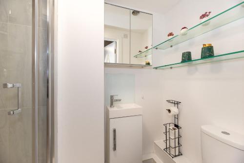 uma casa de banho branca com um lavatório e um espelho em Small and Trendy studio 3B em Londres