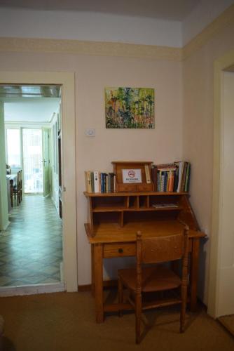 a room with a wooden piano and a shelf with books at Guest House Tisza Ház in Senta